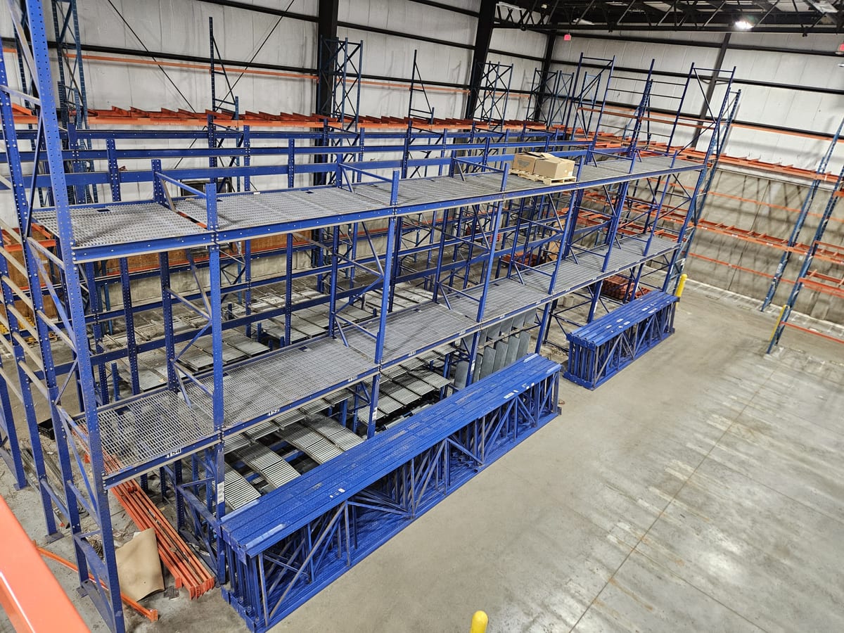 Multi-level structural pick module with steel grate walkways and flow rack lanes in a beverage warehouse being relocated